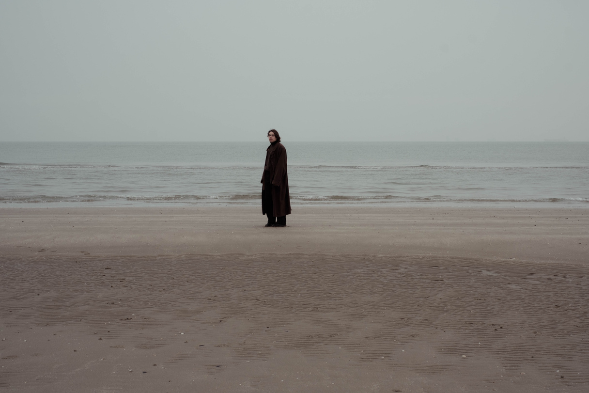 Stylish man standing on coast near sea