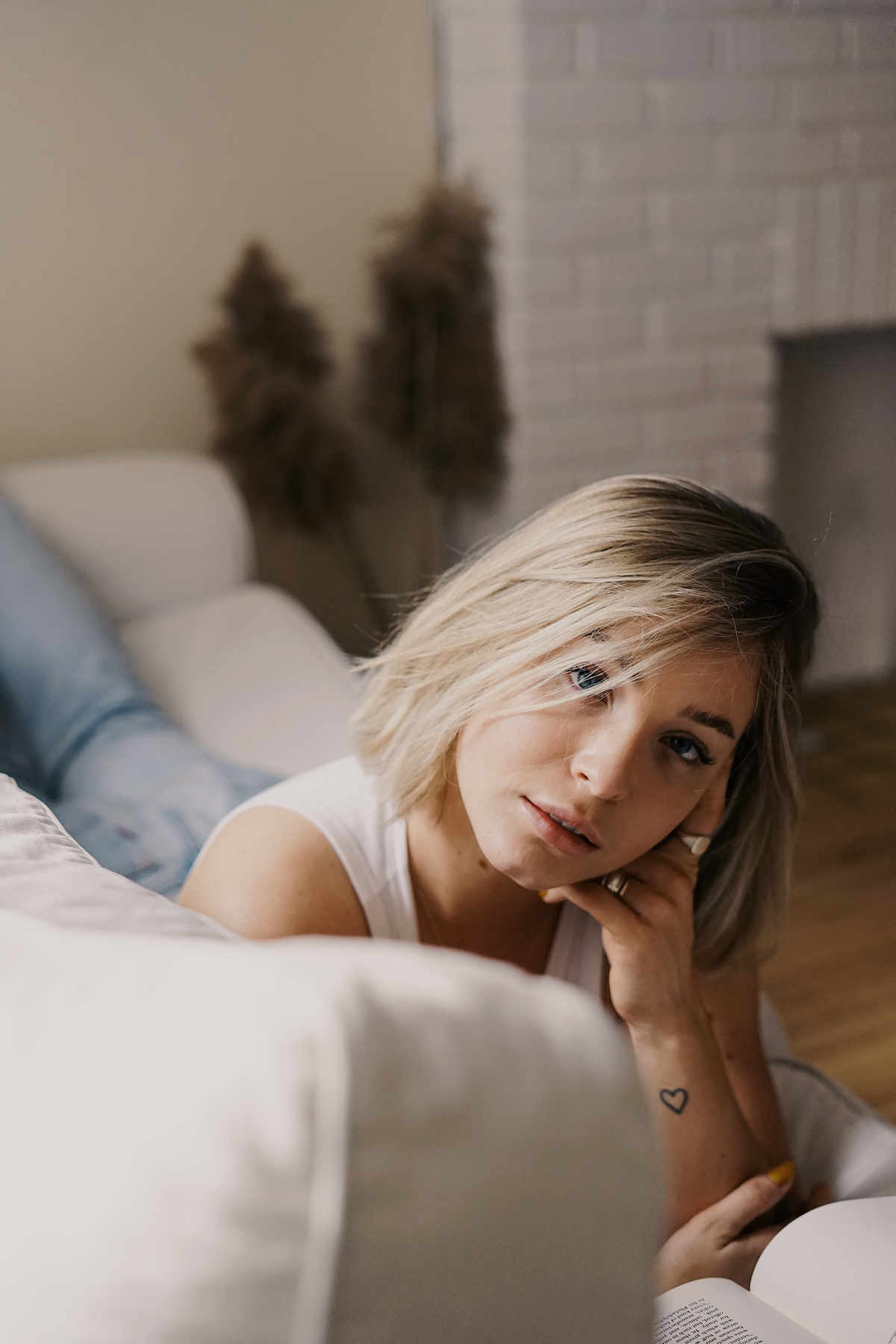 Woman in White Tank Top Lying on Bed